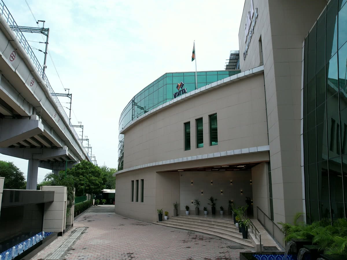 Curved architectural glass facade and entrance stairs at JDKD Corporate Park